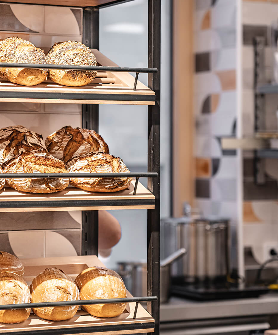 Formrohrregal mit Reling und Magnetkreidetafel inklusive Bäckerware in der Bäckerei manuell in Oberneukirchen - Interior Design by id Werkstatt 