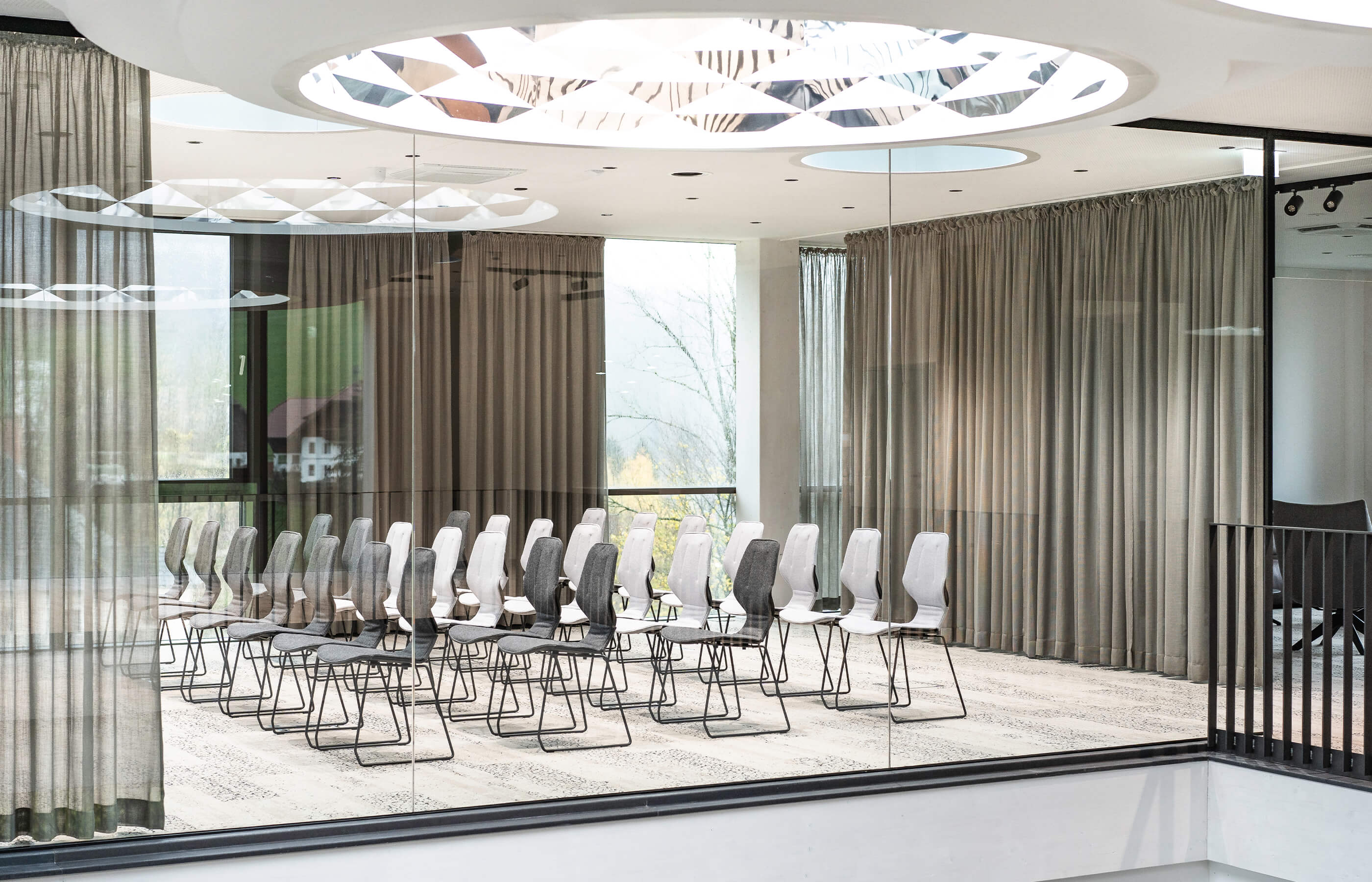 Ein Konferenzraum mit Stühlen und einem großen Fenster in der Biogena Health World in Koppl
