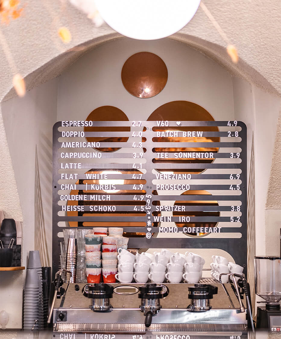 Kaffeemaschine mit dahinter liegender Produktauflistung mit Magnetbuchstaben auf Stahlbuchstabenpinwand