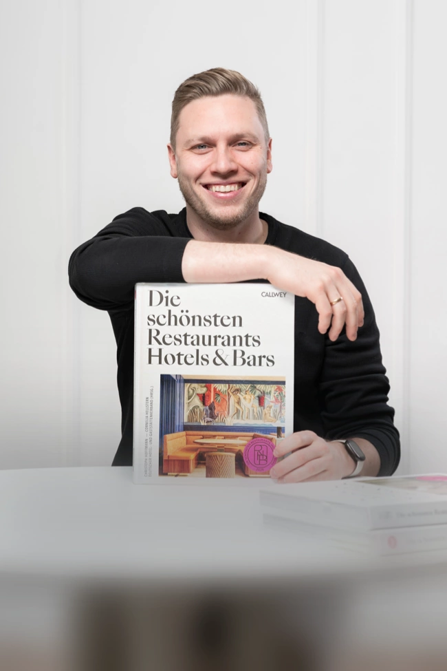 Moritz Reisenberger mit dem neuen Restaurant- und Hotelführer 2026 von Callwey