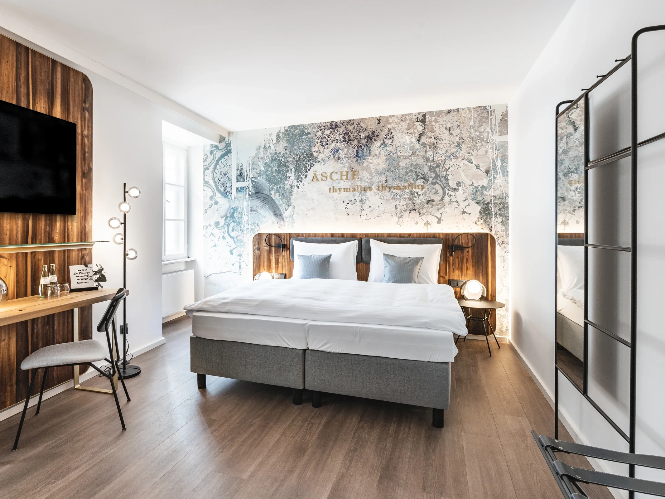 Hotelzimmer im Blauer Bock Passau mit Boxspringbett, kunstvoller Wandtapete mit goldenem „Äsche