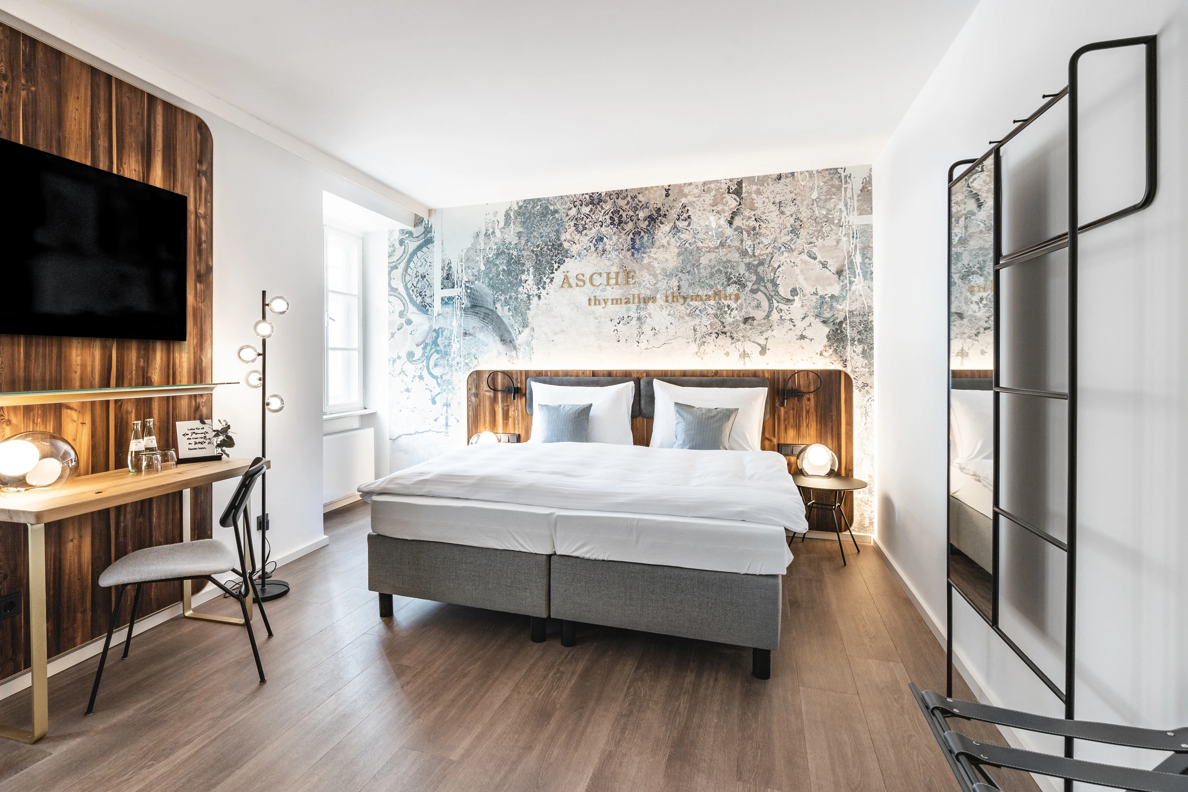 Hotelzimmer im Blauer Bock Passau mit Boxspringbett, kunstvoller Wandtapete mit goldenem „Äsche