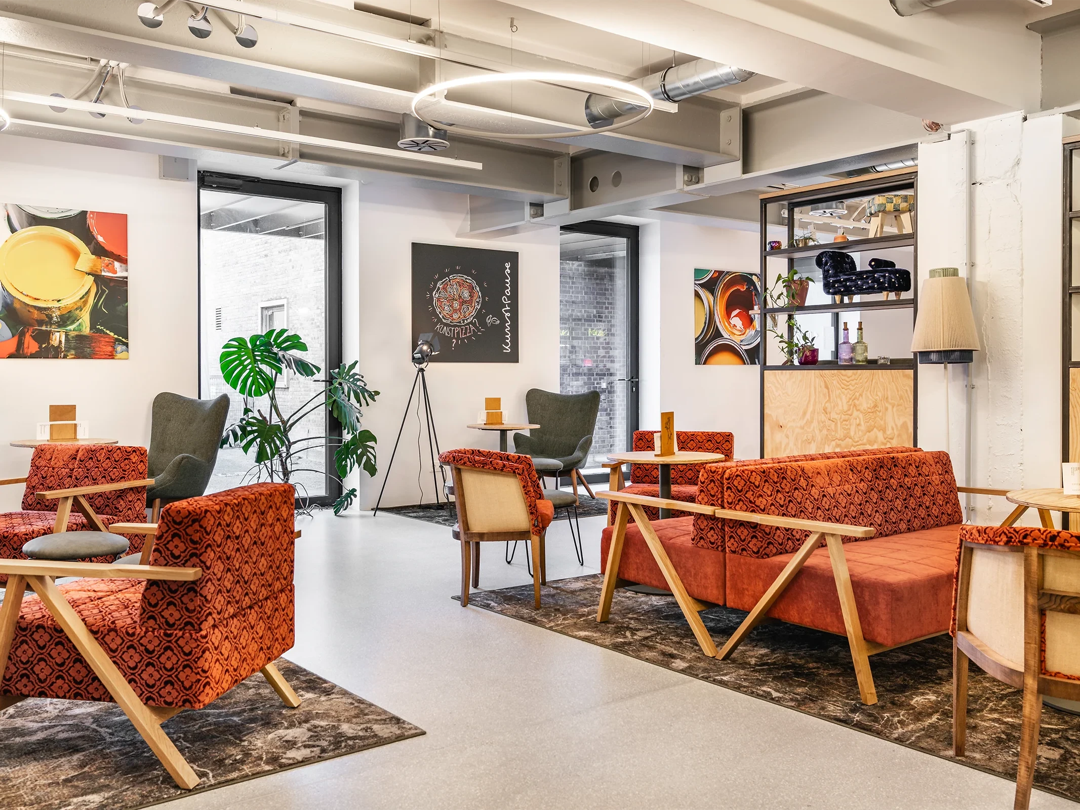 Moderne Lounge in der Innenarchitektur mit maßgefertigten Sitzmöbeln, warmem Farbkonzept und offenem Raumdesign