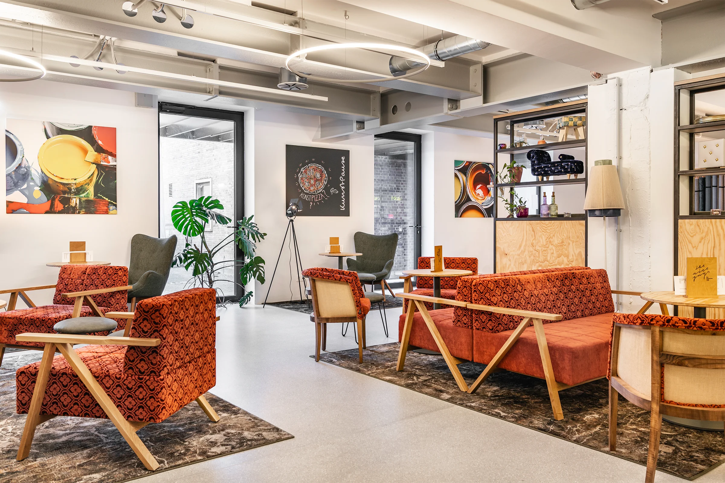 Moderne Lounge in der Innenarchitektur mit maßgefertigten Sitzmöbeln, warmem Farbkonzept und offenem Raumdesign