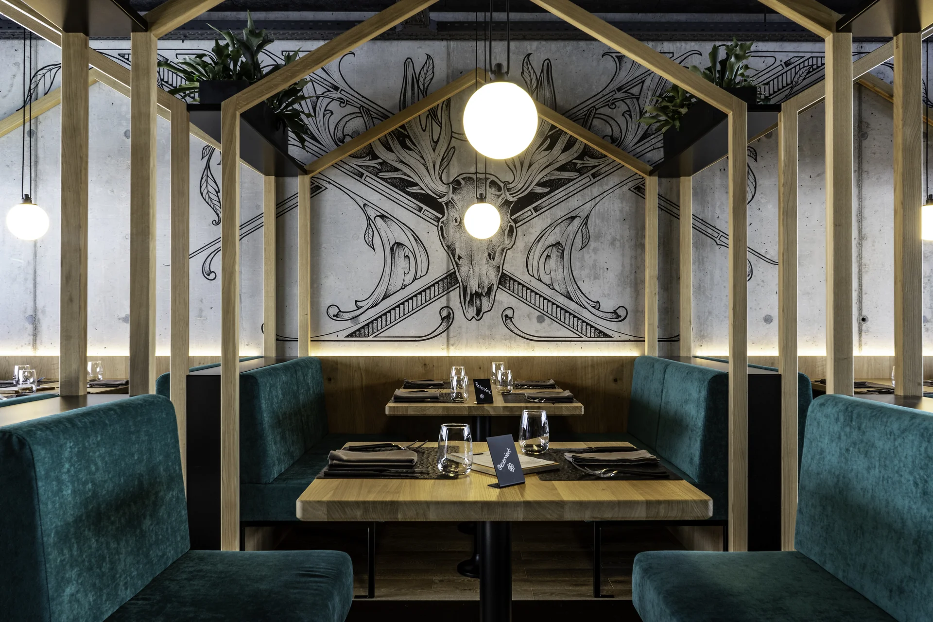 Private-Dining-Bereich des Scanaua mit Holzrahmen-Konstruktion, Hirsch-Wandbild auf Beton und türkisen Samtbänken.