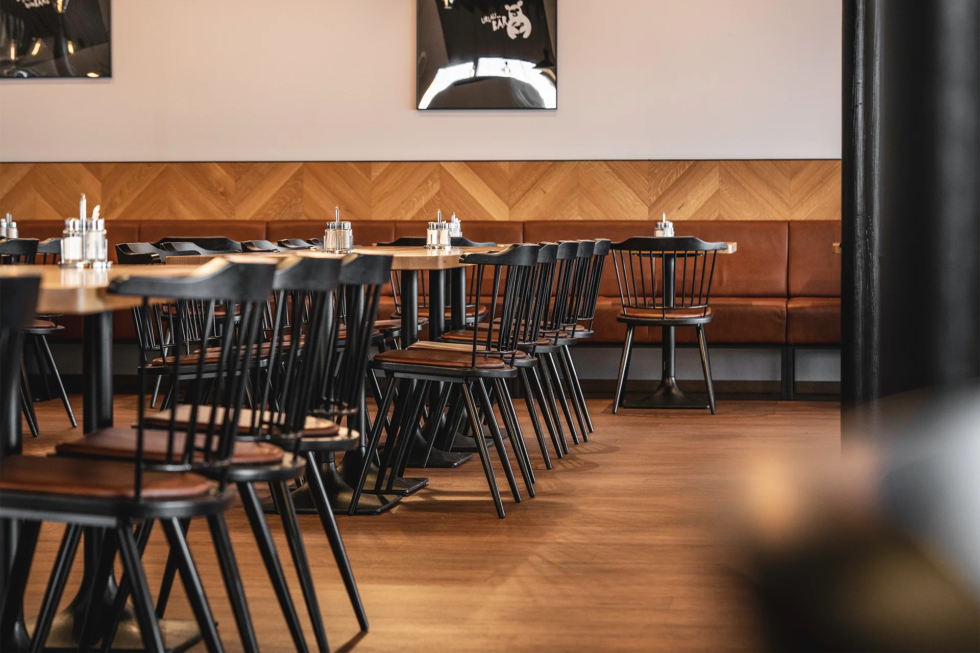 Sitzbereich im SB Restaurant mit Holzstühlen, Lederbänken und warmem Materialkonzept für ein modernes Schnitzel Lokal