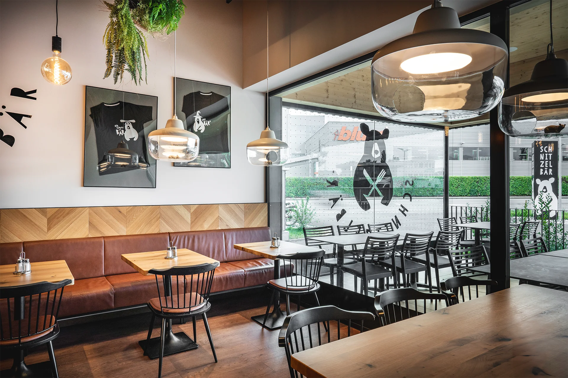 Fensterbereich mit Sitzplätzen im SB Restaurant und Blickbezug zum Außenbereich sowie familienfreundlichem Ambiente