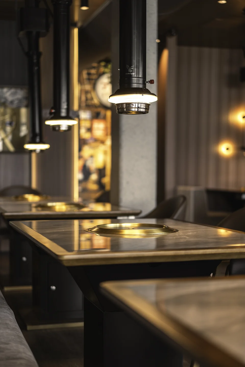 Detailaufnahme eines Tischgrills mit Pendelleuchten im Restaurant Akiko.