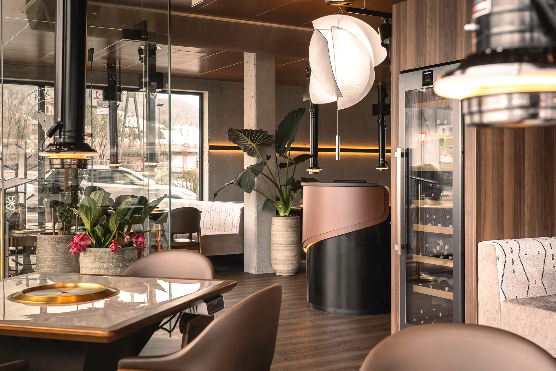 Sitzbereich mit Blumendekoration und Weinkühlschrank im Hintergrund im Akiko Bürs.