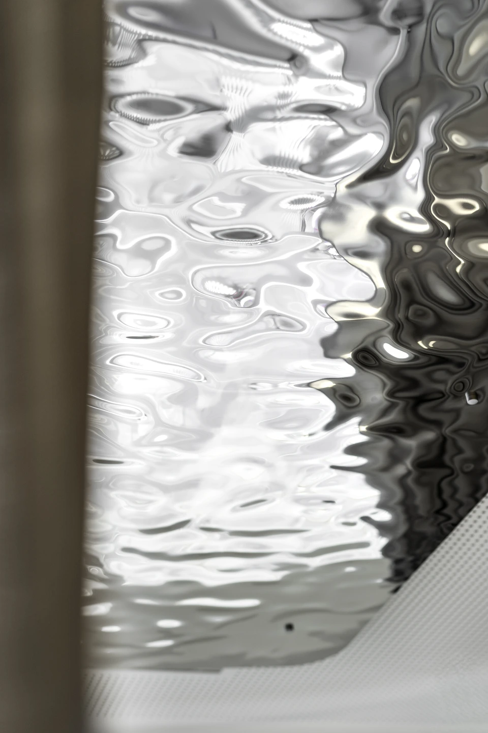 Detail der silbernen Metalldecke mit organischer Wellenstruktur im Breath-in Room der Biogena Plaza Wien.